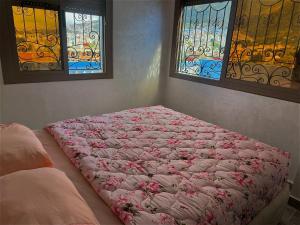 Bett in einem Schlafzimmer mit Buntglasfenstern in der Unterkunft Duplex panoramique avec jardin in Chefchaouen