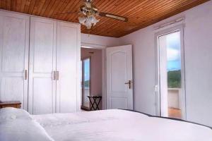 una camera con letto bianco e ventilatore a soffitto di Seaside holiday house Veli Rat, Dugi otok - 22718 a Sali (Sale)