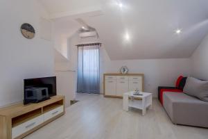 a living room with a couch and a tv at Apartments with a parking space Losinj, Losinj - 22952 in Mali Lošinj