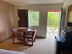 ein Hotelzimmer mit einem Tisch und Stühlen sowie einem Wohnzimmer in der Unterkunft Eagle Motel in Manitou Springs