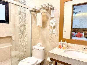 a bathroom with a toilet and a sink and a shower at Grand Fifty Suites in Playa del Carmen