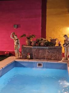 a swimming pool in a room with statues of people at Hospedaje Los 7 Arcangeles in Termas de Río Hondo