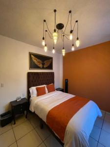 een slaapkamer met een bed en een kroonluchter bij Hotel & Balneario Los Angeles in Taxco de Alarcón