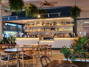 a restaurant with tables and chairs and a bar at Bargara Beach Hotel in Bargara