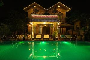 a house with a swimming pool at night at Tam Coc Cuong Hieu Homestay in Ninh Binh
