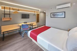 a hotel room with a bed and a desk at City Express by Marriott Chihuahua in Chihuahua