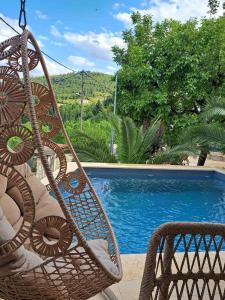 una sedia in vimini seduta accanto alla piscina di Villagio inn Suite & Spa a Soúlion