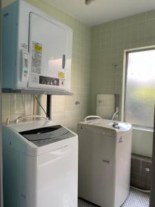 a small kitchen with a sink and a microwave at 北アルプス麓のゲストハウス林屋 204 in Omachi