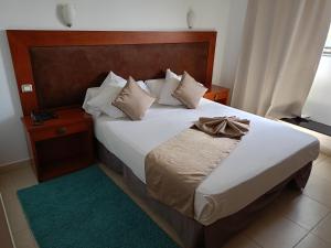 een slaapkamer met een groot bed met een boog erop bij Hôtels Jardy in Bab Ezzouar