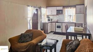 a kitchen with a couch and a table in a room at Ces’t Lavie ultra apartments in Gros Islet