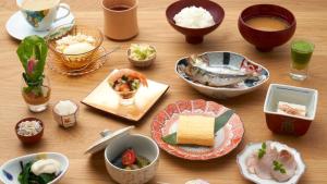 a wooden table topped with bowls and plates of food at 黒梅屋 Kurumiya in Kanazawa +16 photos