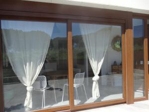 カルデス・デ・マラベーリャにあるCasa Ateneaのパティオにカーテンと椅子のある窓