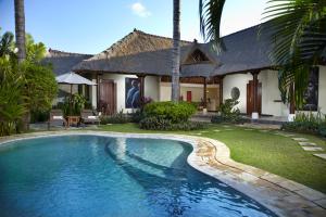 - une piscine en face d'une maison dans l'établissement Jimbaran Bay Villas, à Jimbaran