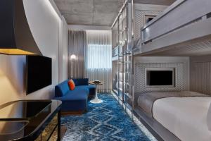 Habitación de hotel con cama y silla azul en W Aspen en Aspen
