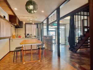 a kitchen and dining room with a table and chairs at 北アルプス麓のゲストハウス林屋 in Omachi