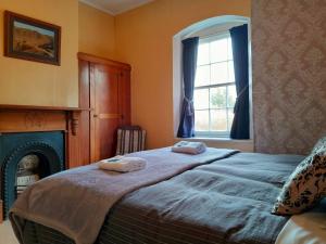 a bedroom with a bed with two towels on it at Peter's Farm Lodge in Waipiata