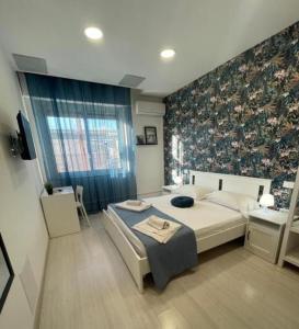 een slaapkamer met een bed en een bloemenmuur bij Central Rooms 128 in Palermo