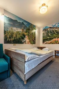 um quarto com uma cama grande e uma cadeira azul em Willa Baja 2 em Zakopane