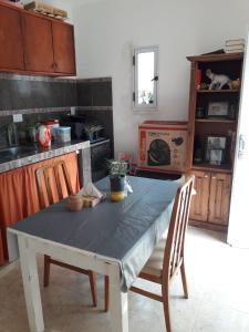uma cozinha com uma mesa com duas cadeiras e uma mesa com sidx sidx sidx em Kasik sacat em Sebastián Elcano