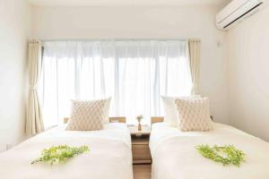 2 camas en una habitación con ventana en 渋谷3分でベット4台の3ベットルーム65平米の一軒家, en Tokio