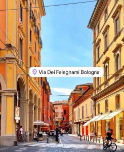 a city street with buildings and a person riding a bike at BolognaBySide-DE FALEGNAMI in Bologna
