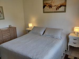 a bedroom with a white bed with two night stands and two lamps at Beautiful holiday location in Solís in Balneario Solís