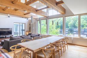 倶知安町にあるChalet Murasakiの大きなリビングルーム(大きなテーブル、椅子付)
