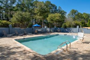 una piscina con sillas, una mesa y una mesa de picnic en Fairfield Inn & Suites by Marriott Charleston North/Ashley Phosphate en Charleston