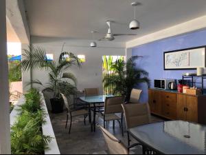 Ixaya في بويرتو فايارتا: غرفة طعام بها طاولات وكراسي ونباتات
