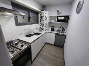 a small kitchen with a stove and a sink at Emilio es un precioso departamento quinta sección Mendoza in Villa Marini