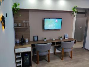 a table with two chairs and a television on a wall at Emilio es un precioso departamento quinta sección Mendoza in Villa Marini