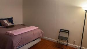 ein Schlafzimmer mit einem Bett, einer Lampe und einem Stuhl in der Unterkunft Westminster Zen Home in Westminster + 12 Fotos