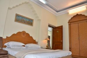 a bedroom with a large bed with a wooden headboard at Bajaj Indian Home Stay in New Delhi