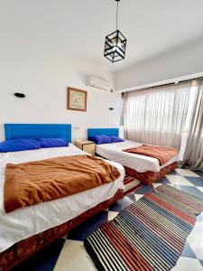 a bedroom with two beds and a rug at Dahab Vibes Hotel in Dahab