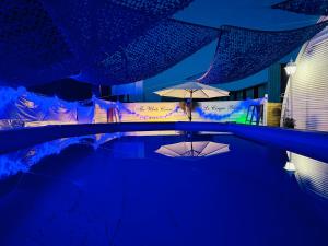 a pool with an umbrella and a table with umbrellas at Maison avec piscine in Antibes