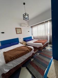 a bedroom with two beds and a window in it at Dahab Vibes Hotel in Dahab