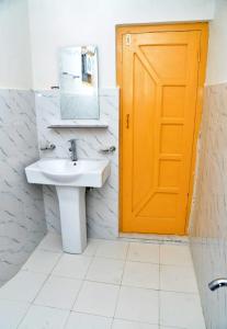a bathroom with a sink and a orange door at Tufail palace in Skardu