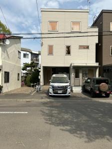 a car parked in a parking lot in front of a building at ハーモニー地下鉄幌平橋駅徒歩6分市電行啓通駅2分 in Sapporo