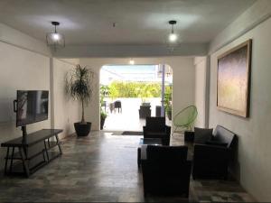 - un salon avec des chaises, une table et une télévision dans l'établissement Ixaya, à Puerto Vallarta