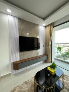 ein Wohnzimmer mit einem schwarzen Tisch und einem TV in der Unterkunft Căn hộ 2 phòng ngủ tầng 10 chung cư cao cấp Sophia Center in Ấp Rạch Mẹo