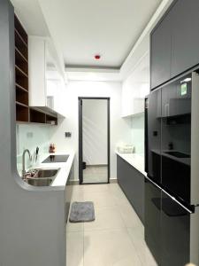 eine Küche mit einer Spüle und einem schwarzen Kühlschrank in der Unterkunft Căn hộ 2 phòng ngủ tầng 10 chung cư cao cấp Sophia Center in Ấp Rạch Mẹo