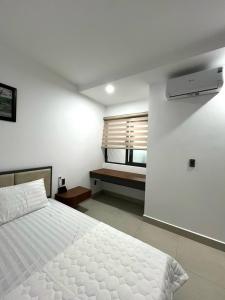 een slaapkamer met een wit bed en een raam bij Căn hộ 2 phòng ngủ tầng 10 chung cư cao cấp Sophia Center in Ấp Rạch Mẹo