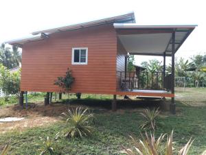 a small house with a roof on a yard at RakSuan Homestay บ้านพัก1ห้องนอนเตียงคิงไซร์ in Khao Lak