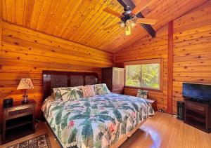 a bedroom with a bed and a ceiling fan at Volcano Hideaway Cabin as seen on HGTV in Volcano