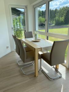 a dining room with a wooden table and chairs at Ferienwohnung Hoherting in Prien am Chiemsee