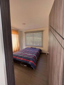1 dormitorio con cama y ventana en Casa de Campo Moderna Ubaté - Sector La Laja, en Ubaté