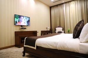 a hotel room with a bed and a flat screen tv at VRC CITY HEART in Bathinda