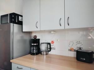 a kitchen counter with a coffee maker and a refrigerator at Sławików in Rybnik +6 photos