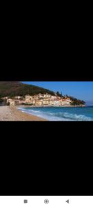 two pictures of a beach with houses on a hill at Apartment D&J 2 in Mošćenička Draga