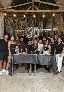 um grupo de pessoas posando em frente a uma mesa em Pangora, habitación privada de Flor de Lis Beach House em Playas